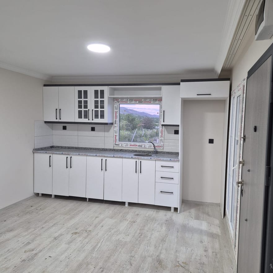 Tamamlanmış prefabrik konutta beyaz mutfak dolapları ve tezgâh